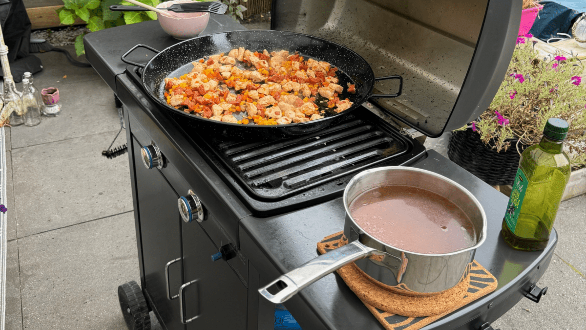 
Zomerse paella met kip, chorizo en doperwten op de barbecue